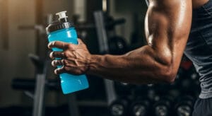 athlete holding water bottle in the gym