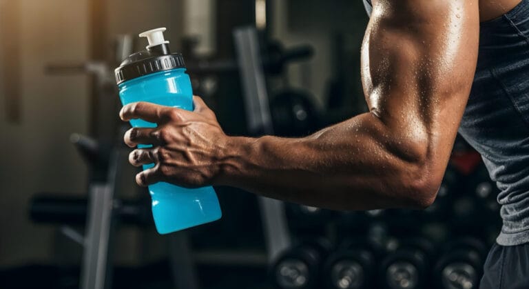 athlete holding water bottle in the gym