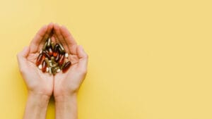 hand holding vitamins | Before You Buy Another Supplement, Read This—5 Must-Know Facts That Could Save Your Health