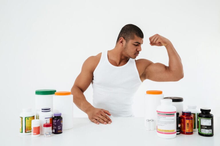 man flexing biceps with supplements on the table | What No One Tells You About Creatine—5 Truths That Could Change Your Results