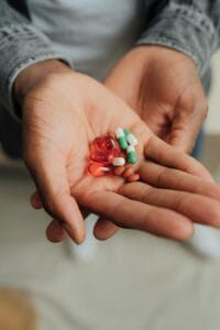 A detailed view of hands holding an assortment of pills and capsules, highlighting healthcare concepts. | You’re Probably Taking Your Supplements at the Wrong Time—Here’s When They Actually Work