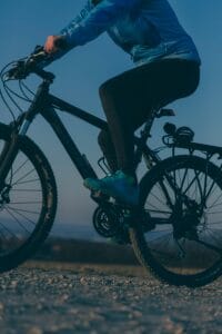 A cyclist enjoying an evening ride on a mountain bike in an outdoor setting.