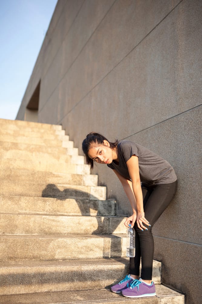 tired woman climbing steps