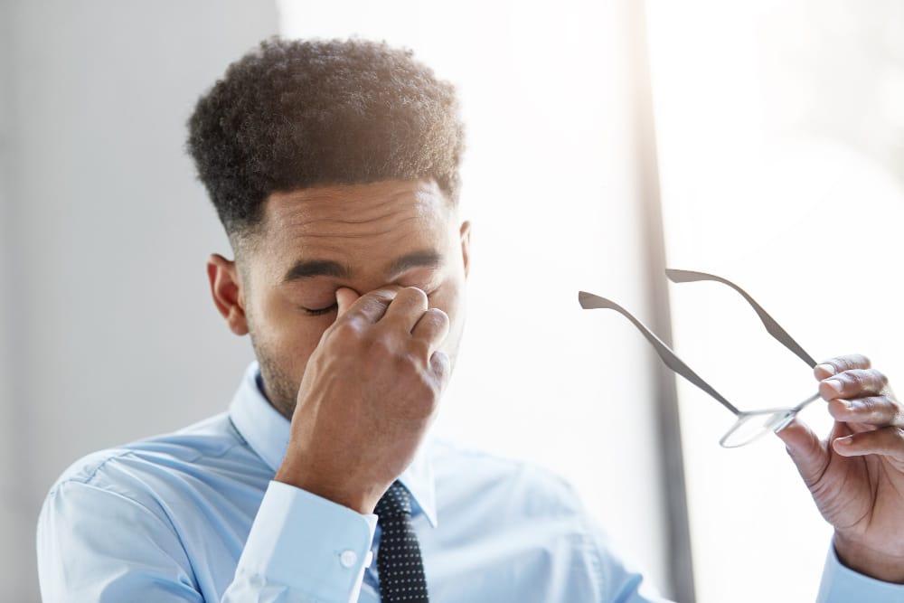 man rubbing his eyes