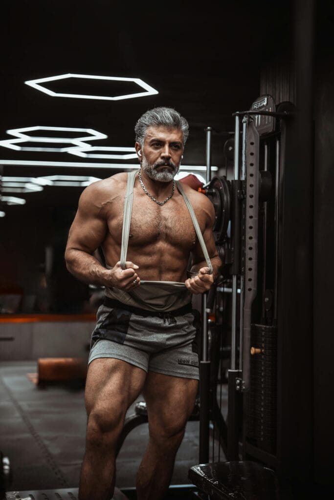 Muscular senior man working out in a contemporary gym, showcasing fitness and strength.
