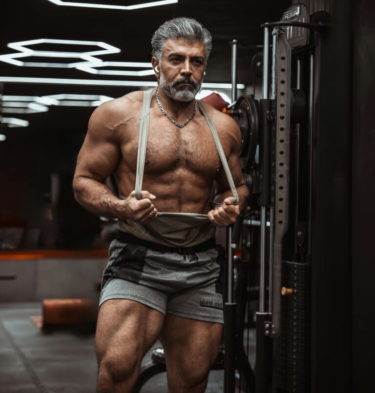 Muscular senior man working out in a contemporary gym, showcasing fitness and strength.