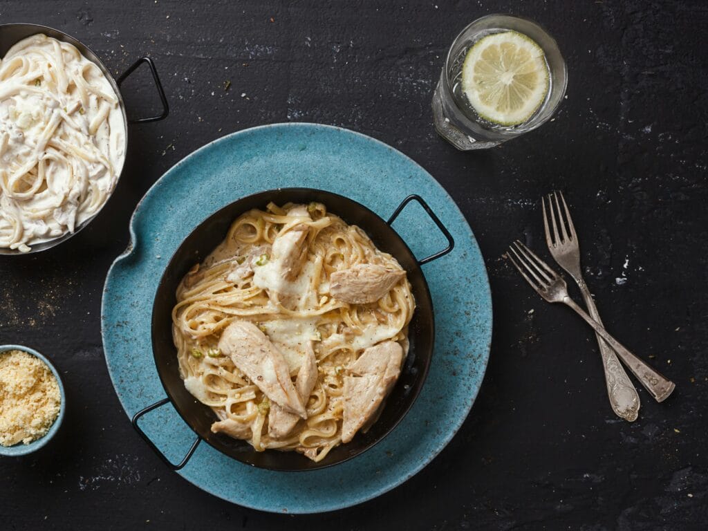 Indulge in a delicious Chicken Alfredo pasta paired with a refreshing lemon drink.