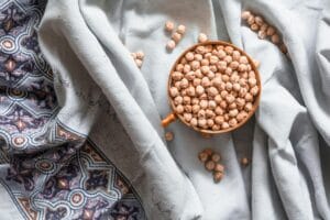 Top view of chickpeas in a bowl on a decorative cloth, creating a cozy kitchen vibe.