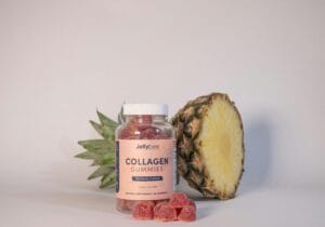 Collagen gummies bottle with a pineapple in a still life setup, promoting health and nutrition.