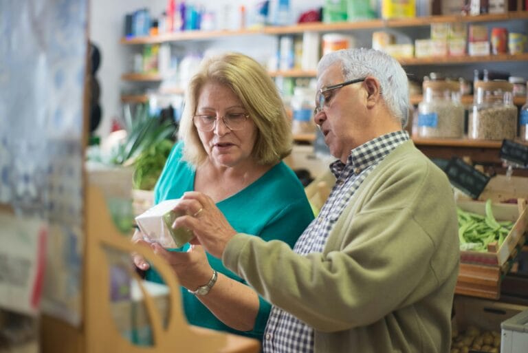 An elderly couple explores products inside a local store in Portugal, highlighting everyday life.