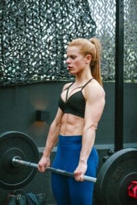 A muscular woman performing weightlifting exercises outdoors in Ciudad de México, showcasing strength and fitness.
