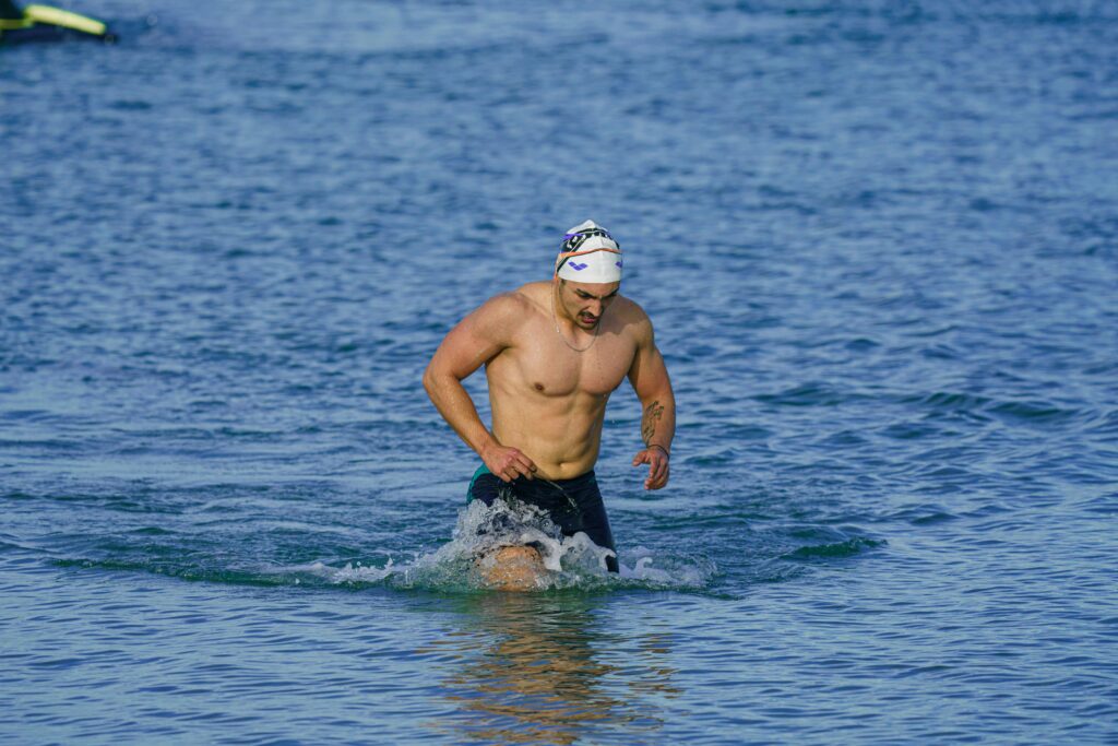 Fit adult male swimmer emerging from the sea in Kuşadası, Türkiye.