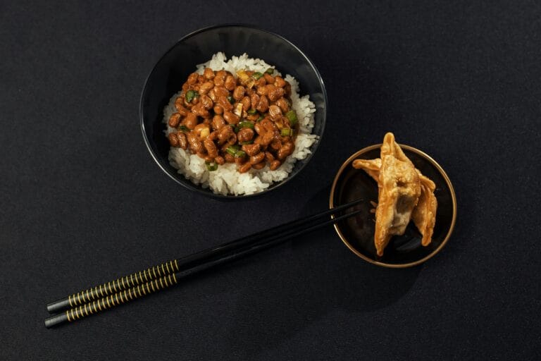 Top view of natto on rice with fried dumplings, perfect for an authentic Japanese meal setting.