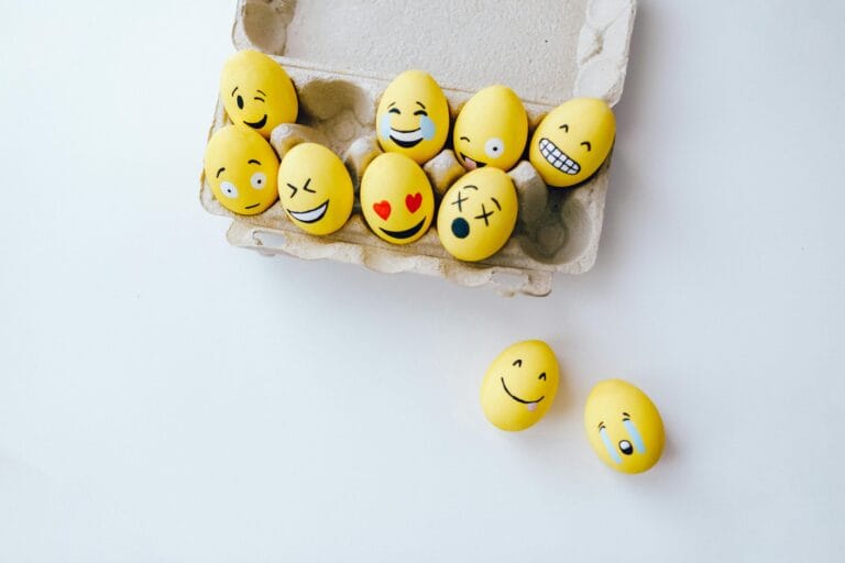 Colorful yellow Easter eggs decorated with emoji faces in a carton, adding a fun and creative touch to the holiday.