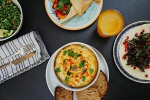 A vibrant Mediterranean meal featuring hummus, tabouli salad, bread, and fresh juice, perfect for healthy eating.
