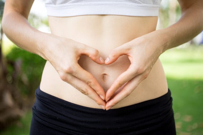 gut health woman using hands to make heart shape