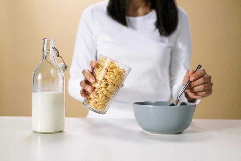 woman about to pour cereal into a bowl
