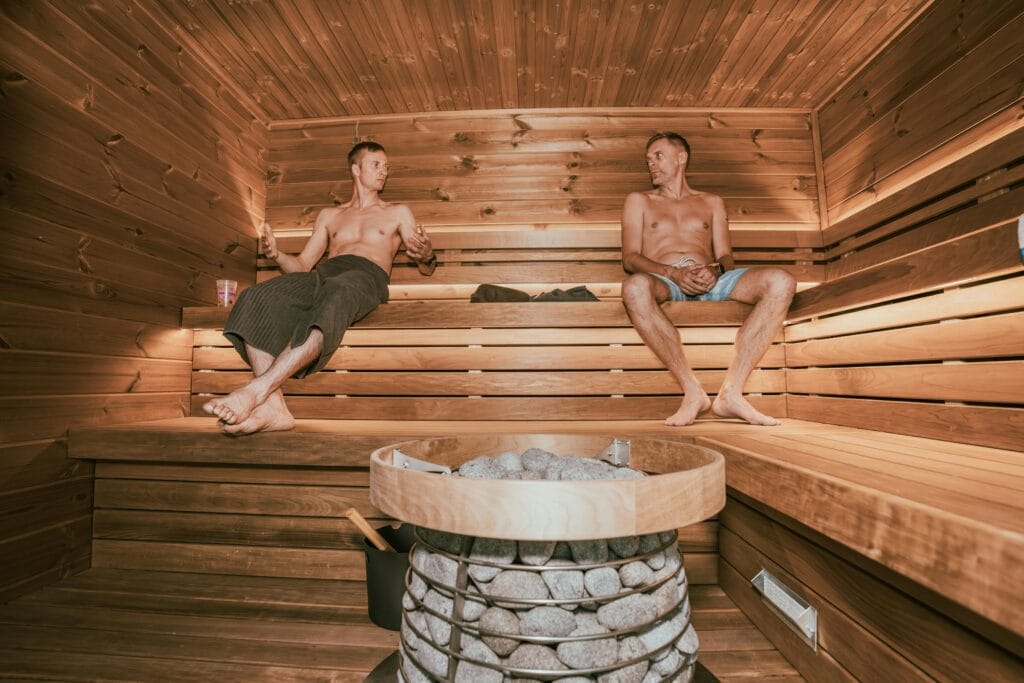 Two men enjoying a relaxing spa experience in a stylish Nordic-designed sauna.