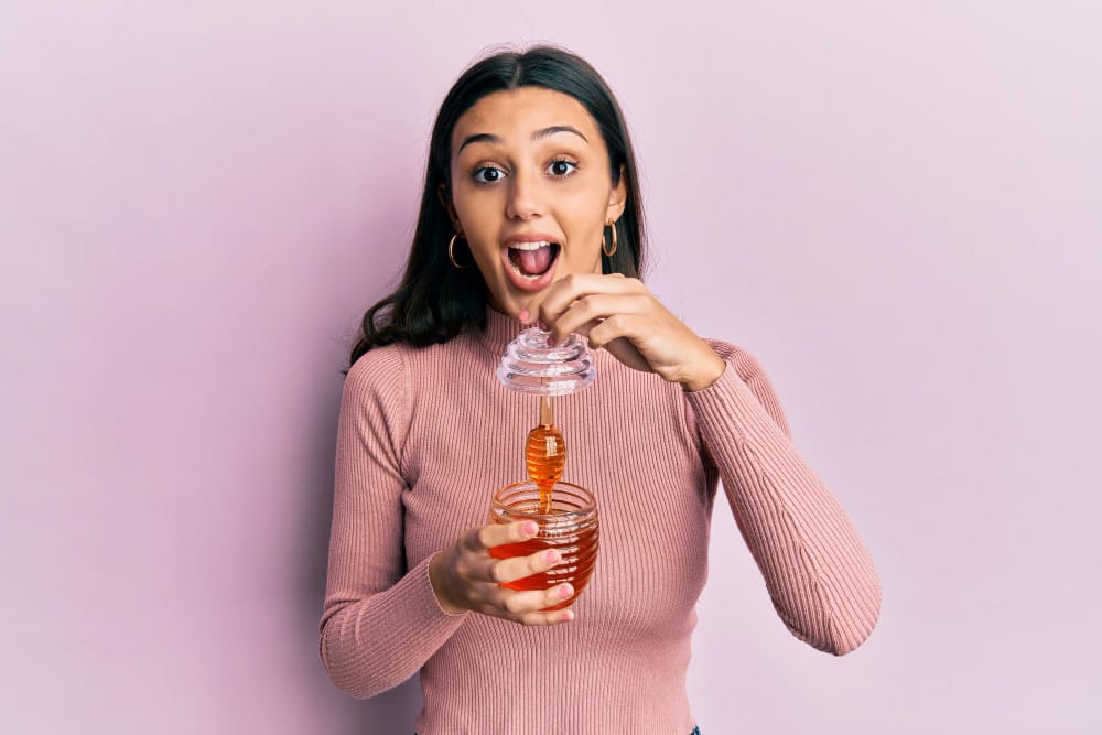 woman holding a honey jar