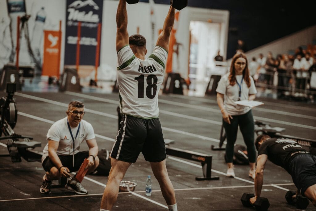 Athletes competing fiercely in an indoor gym, showcasing strength and determination. hyrox