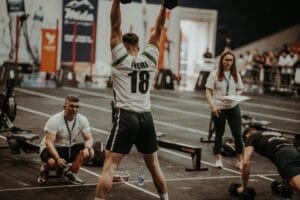 Athletes competing fiercely in an indoor gym, showcasing strength and determination. hyrox