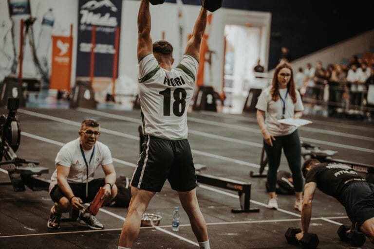 Athletes competing fiercely in an indoor gym, showcasing strength and determination. hyrox