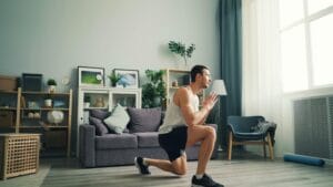 Adult male performing lunges indoors. Home fitness concept.