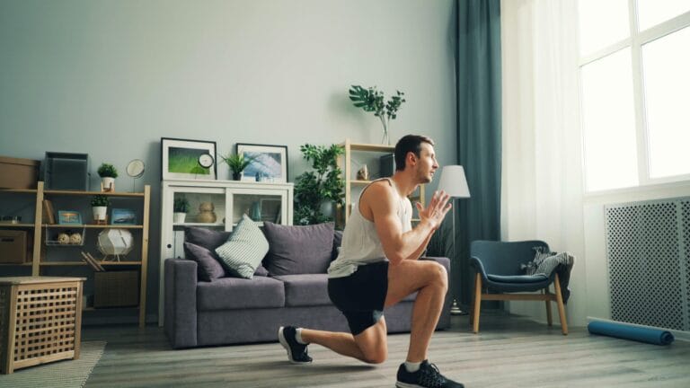 Adult male performing lunges indoors. Home fitness concept.