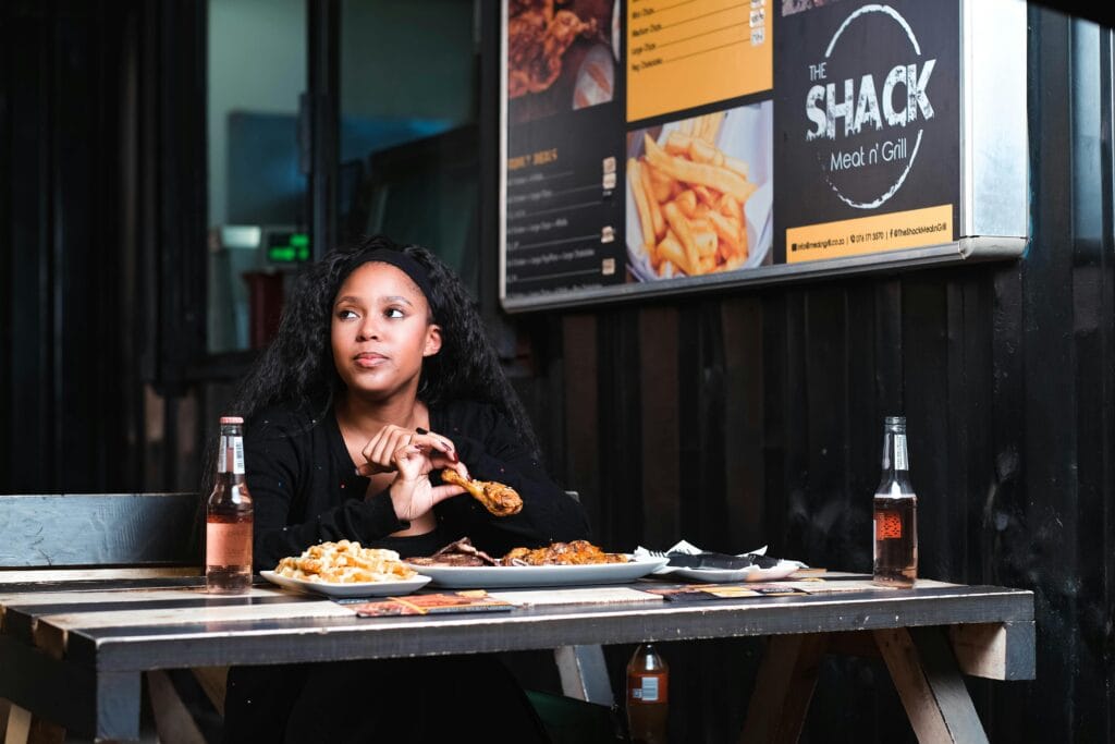 Young woman enjoying a meal at a casual urban diner with tasty food selection.