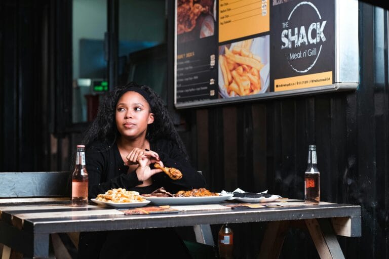 Young woman enjoying a meal at a casual urban diner with tasty food selection.