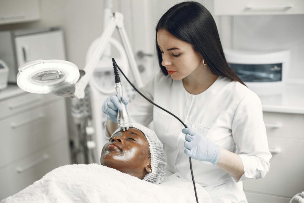 A dermatologist treats a client's skin in a modern clinic, ensuring professional care.