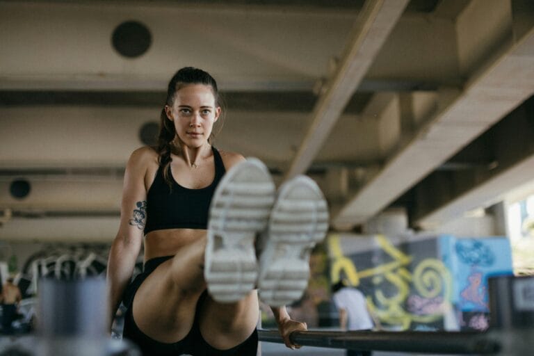 fit Woman exercising in gym wearing sports bra and shorts, focused and determined.