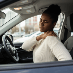woman stretching her back in car due to back pain from driving