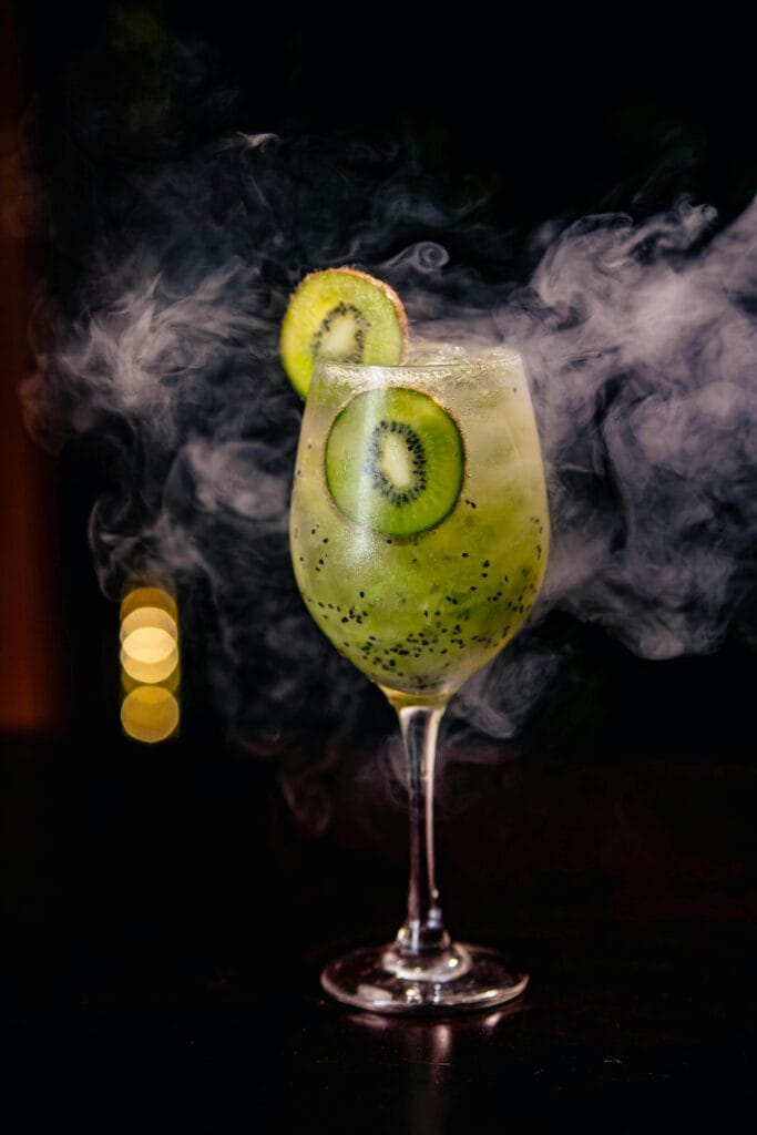 Chilled kiwi cocktail in a glass with smoky visual effect. Perfect for summer refreshment.