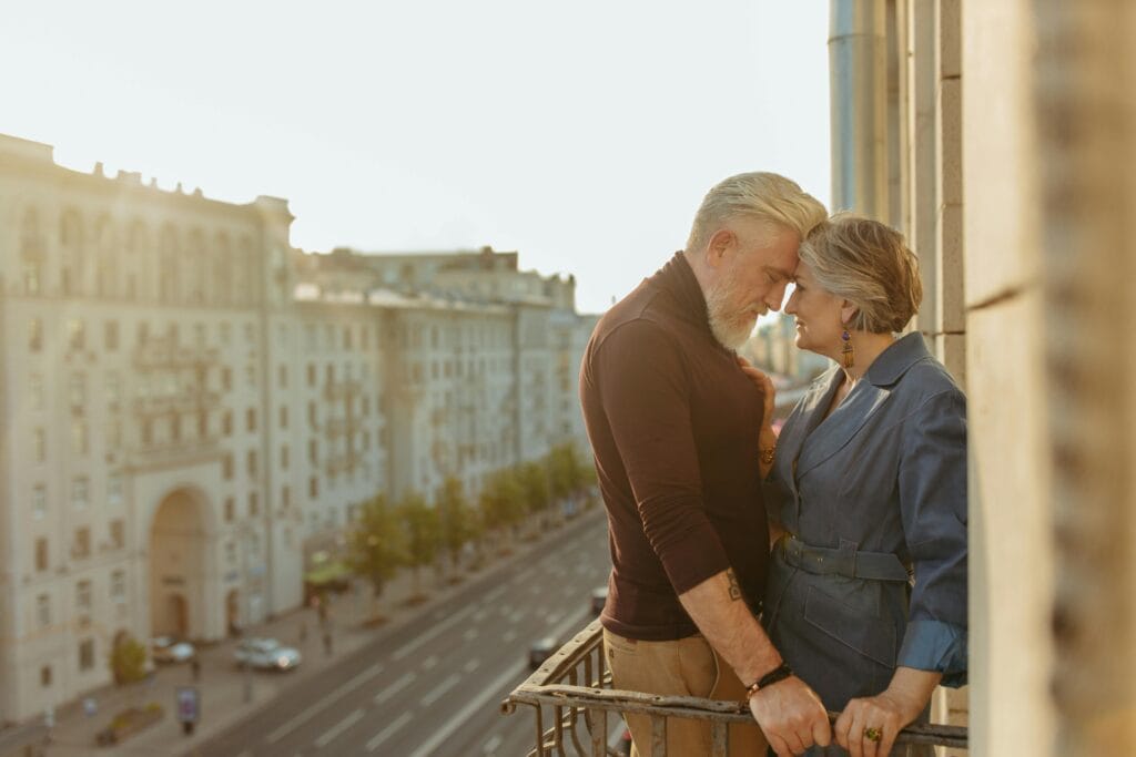Senior couple enjoying a romantic moment on a city balcony, showcasing love and connection.