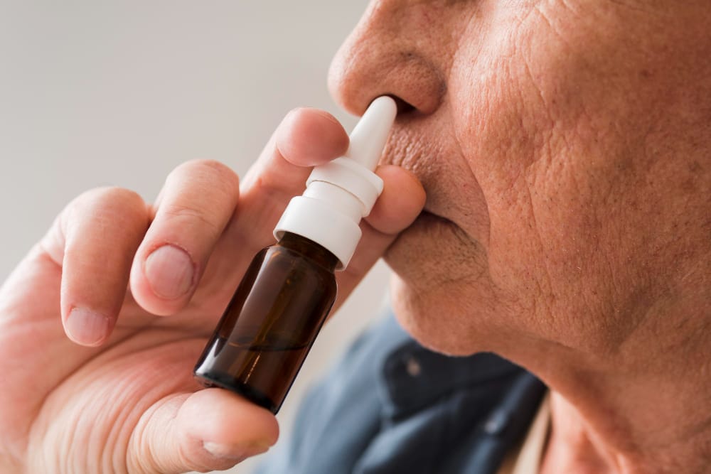 elderly person using nasal spray