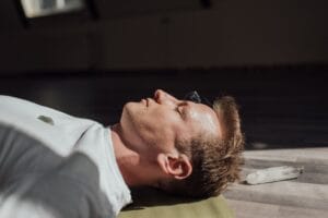 Man meditating indoors with crystals, focusing on relaxation and healing energy.