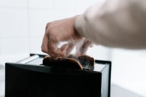 a person taking bread from a toaster