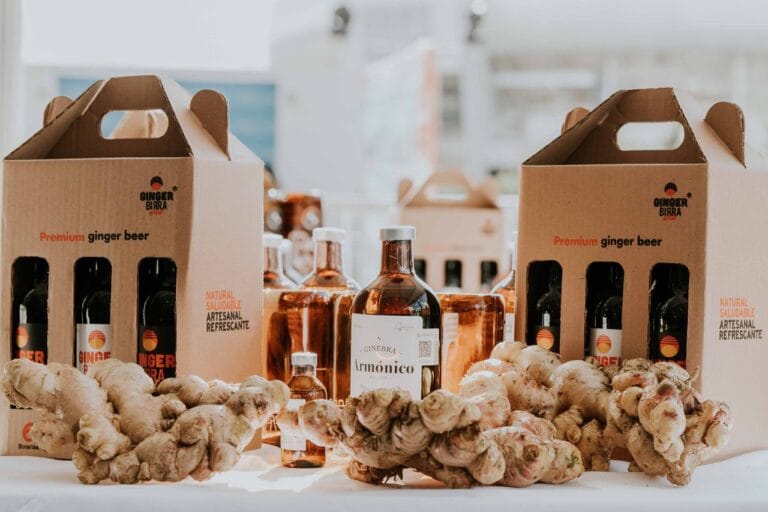 Showcasing premium ginger beer bottles accompanied by fresh ginger roots on a display table.