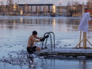 Shirtless man in freezing lake near Ludvika, Sweden, captured during a winter swim. Sublime ice scenery. | cold plunge