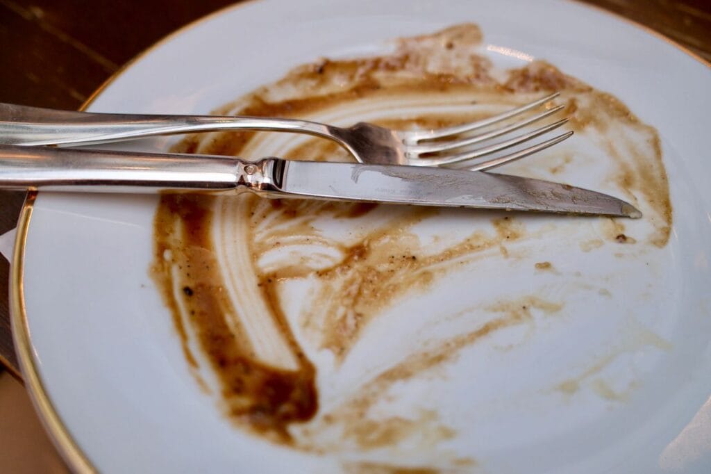 Elegant silverware on a cleaned plate, suggesting a completed meal.