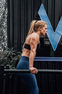 A strong woman in activewear exercises outdoors in Mexico City, showcasing fitness and determination.