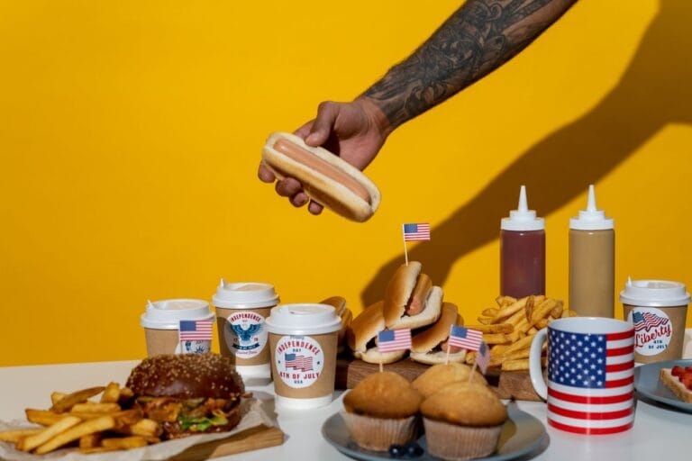 A vibrant display of American food celebrating Independence Day with hot dogs, burgers, and fries.