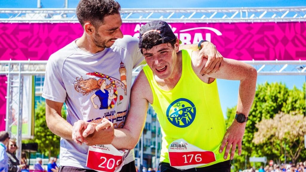 Two athletes celebrate finishing a marathon, highlighting endurance and victory outdoors.