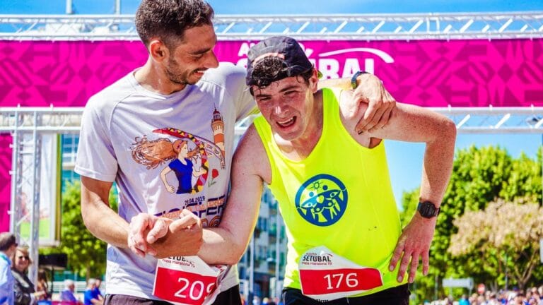 Two athletes celebrate finishing a marathon, highlighting endurance and victory outdoors.
