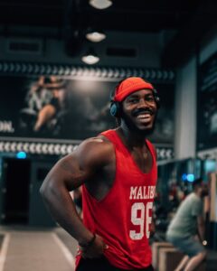 A cheerful athlete enjoying his workout in a gym while listening to music.